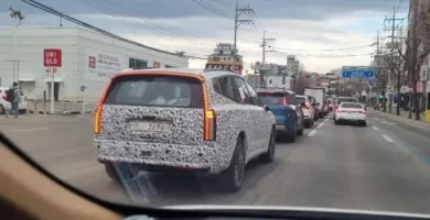 Vehículo con patrón de camuflaje circulando en una calle con tráfico.