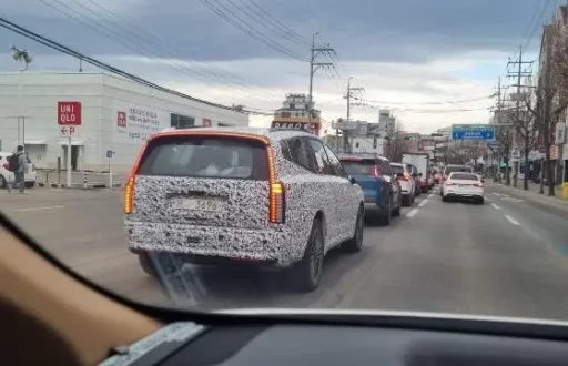 Vehículo con patrón de camuflaje circulando en una calle con tráfico.