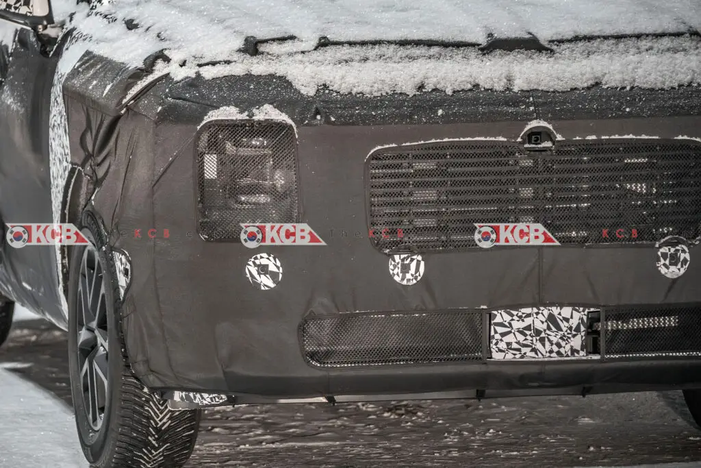 Un vehículo cubierto de camuflaje y nieve en pruebas.