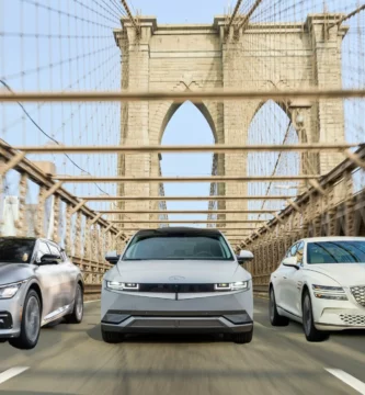 Tres coches eléctricos modernos cruzando un puente icónico.