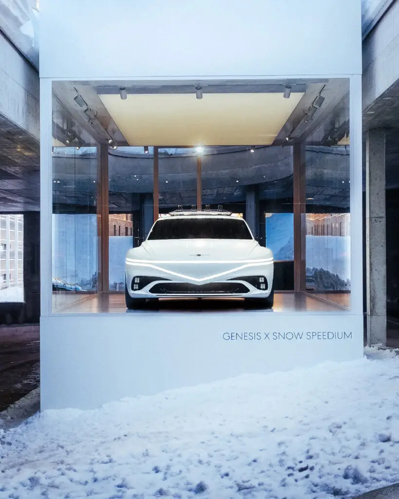 Coche blanco exhibido en un escaparate sobre nieve.