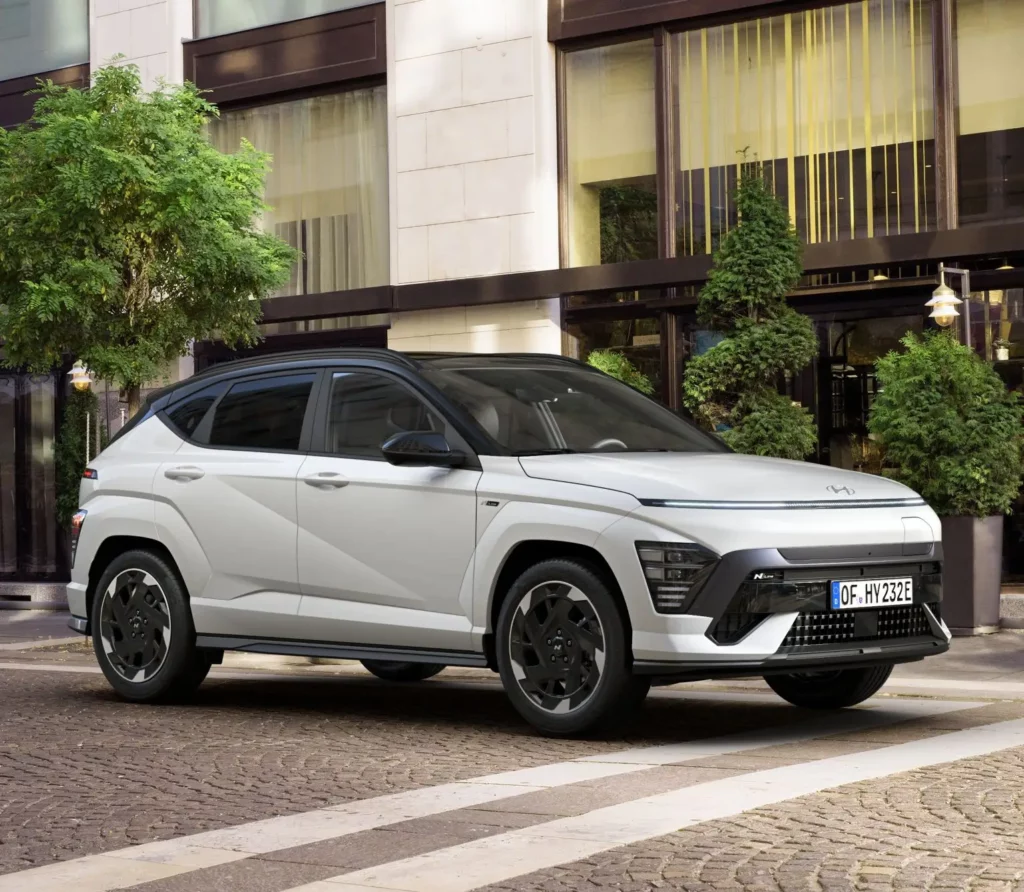 Un SUV eléctrico blanco estacionado frente a un edificio.