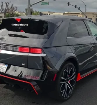 Automóvil negro deportivo en una calle con otros vehículos.