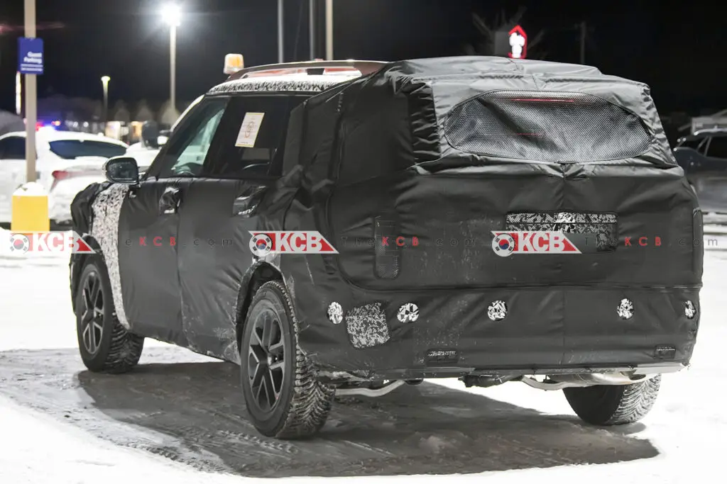 Automóvil camuflado en pruebas en un entorno nevado de noche.
