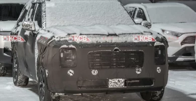 Un vehículo camuflado cubierto de nieve estacionado al aire libre.