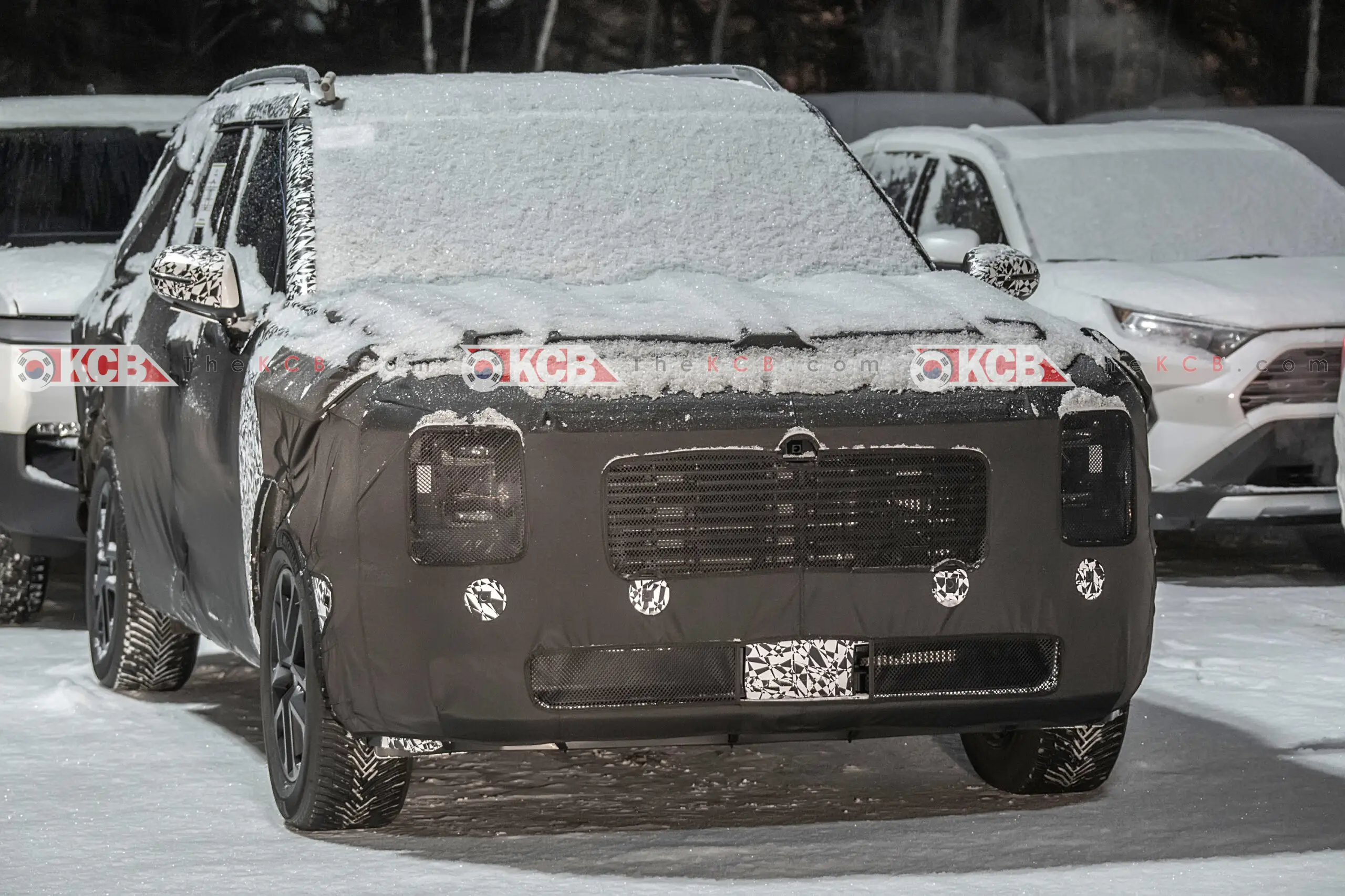 Un vehículo camuflado cubierto de nieve estacionado al aire libre.