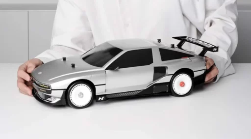 Una persona sostiene un modelo de coche deportivo de juguete.