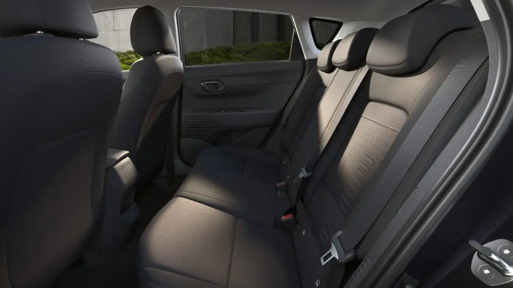 Interior de coche moderno enfocando asientos traseros y puerta abierta.