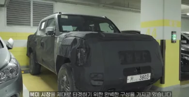 Camioneta cubierta con lona negra en estacionamiento subterráneo.