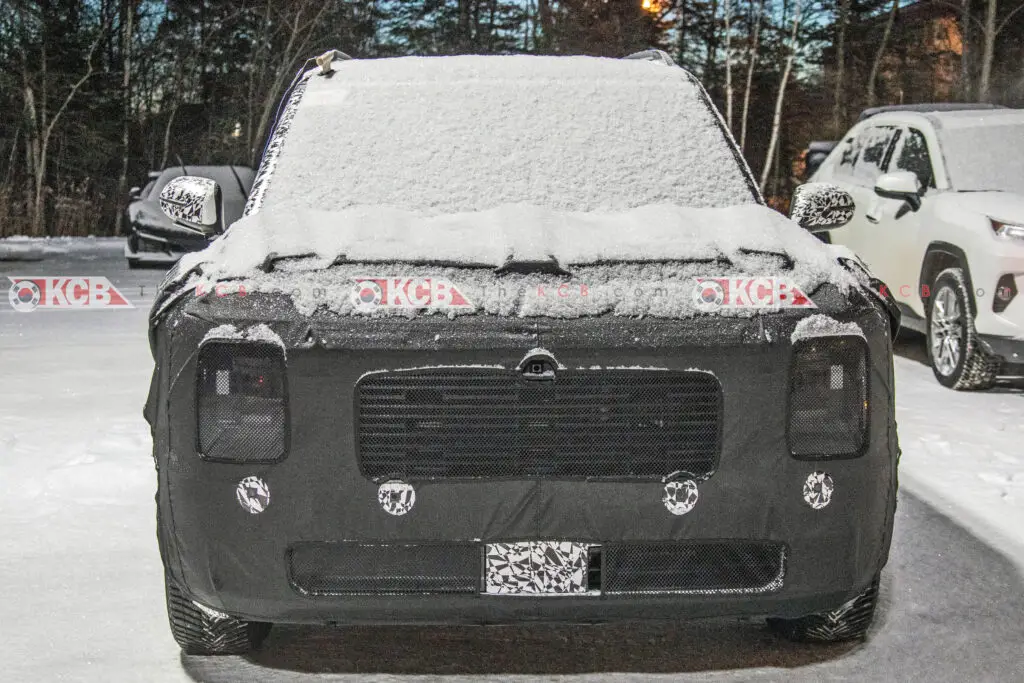 Un vehículo cubierto de nieve en un estacionamiento durante la noche.