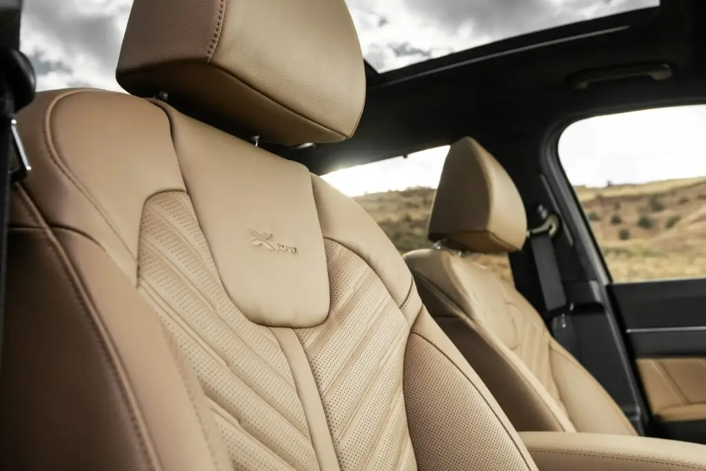 Interior de vehículo de lujo con asientos de cuero beige.