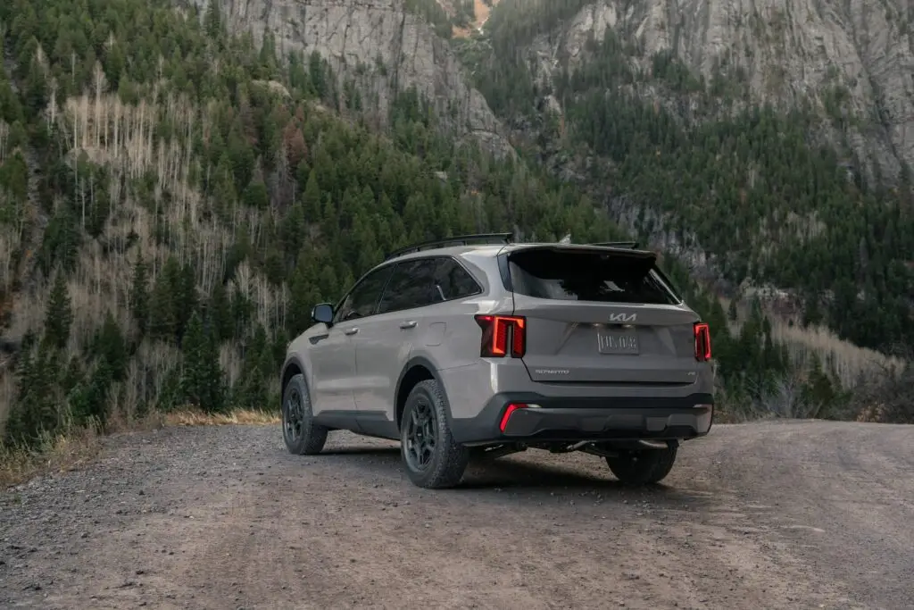 Un SUV gris estacionado en un camino de montaña.