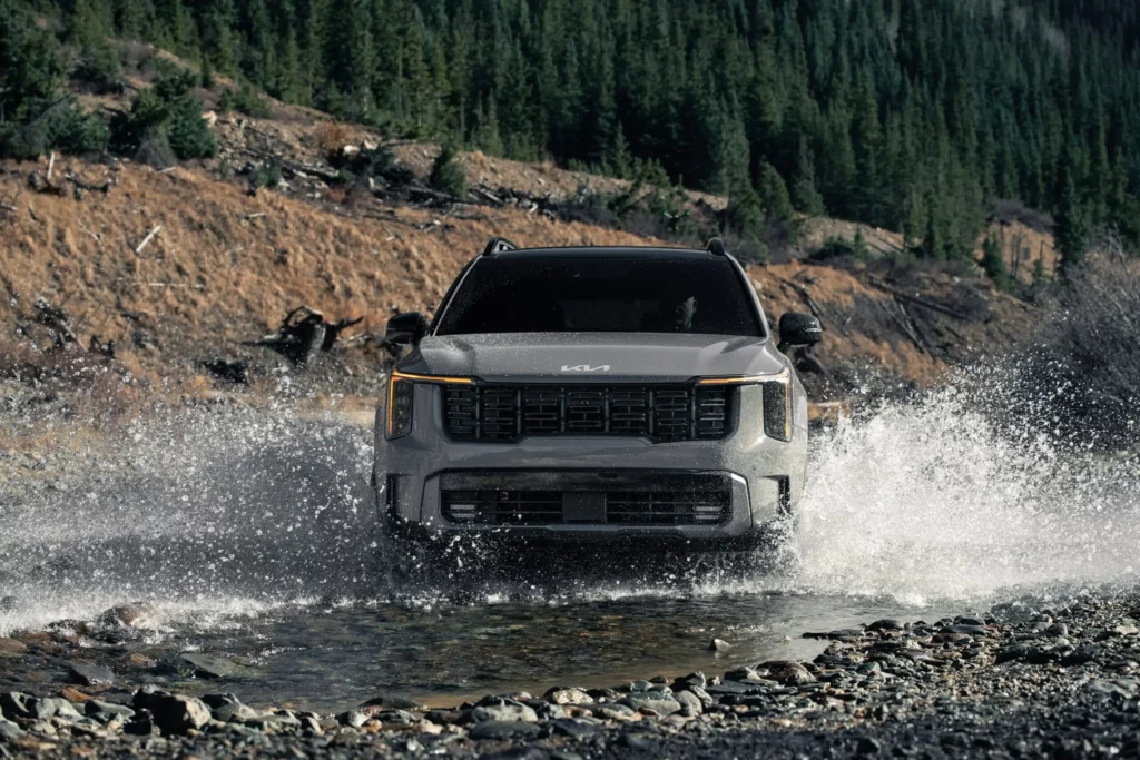 Camioneta cruzando rápidamente un río en la montaña.