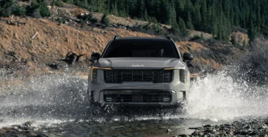 Camioneta cruzando rápidamente un río en la montaña.