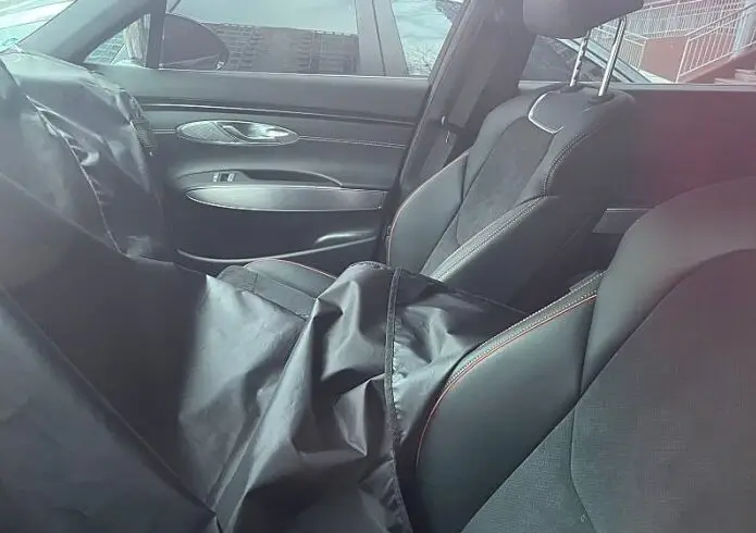 Interior de un coche con asientos de cuero y una chaqueta.