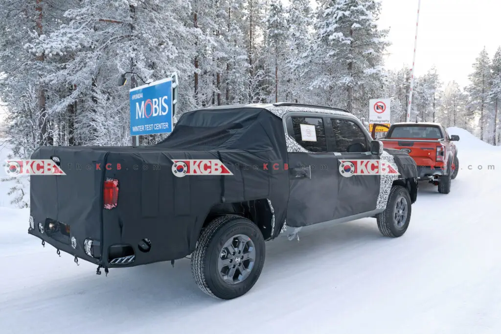 Dos vehículos camuflados probándose en un centro de pruebas invernal.