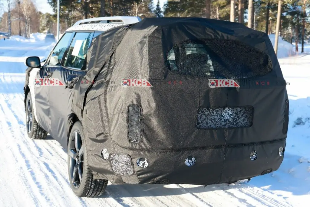 Un auto cubierto con camuflaje para pruebas en la nieve.