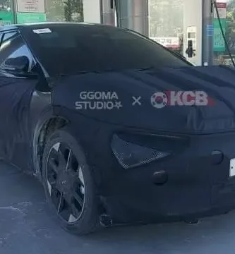 Vehículo camuflado estacionado en una estación de carga eléctrica.