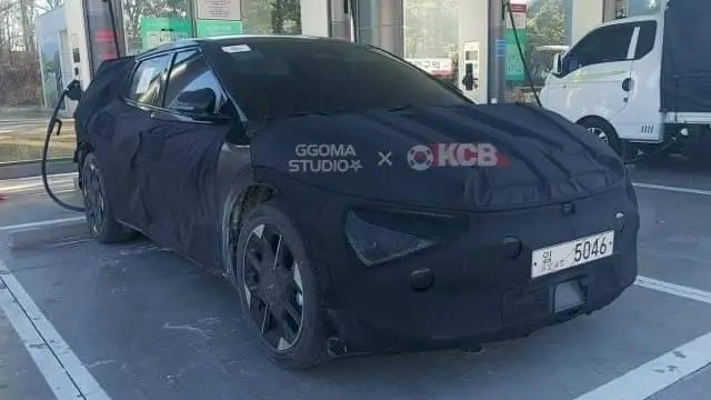 Vehículo camuflado estacionado en una estación de carga eléctrica.