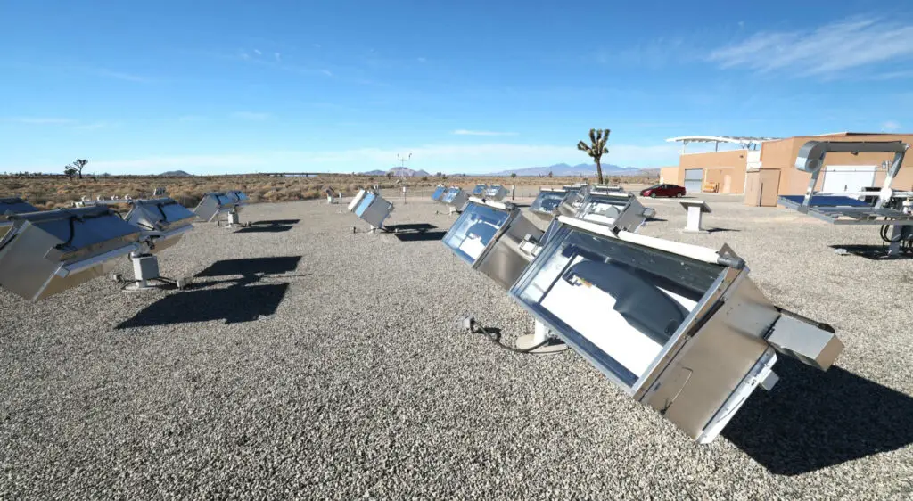 Campo de colectores solares en un desierto bajo un cielo despejado.