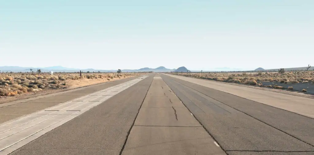 Carretera vacía en un paisaje desértico con cielo claro.