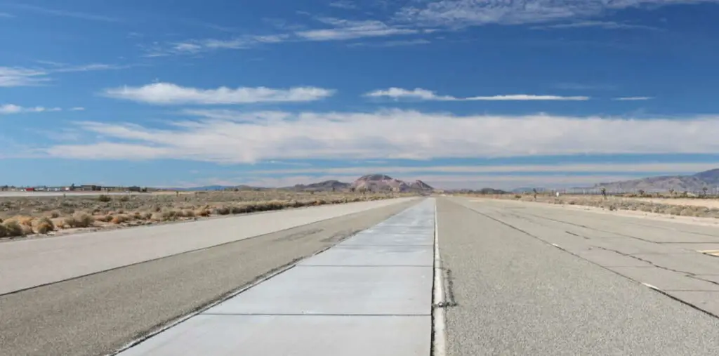 Carretera vacía en un paisaje árido con cielo nublado.