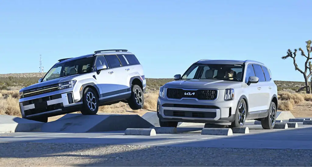 Dos SUV blancos en una pista de pruebas al aire libre.