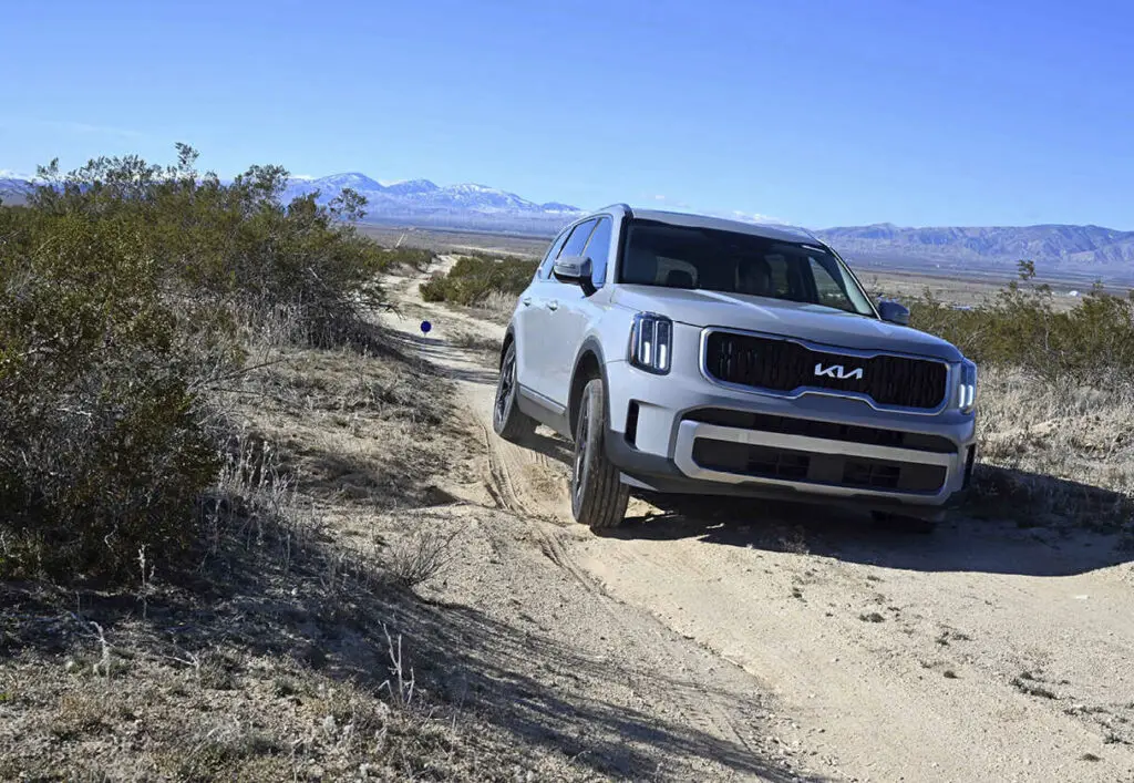 Un vehículo SUV recorriendo un camino de tierra en el desierto.