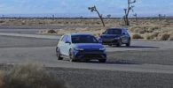 Dos coches modernos en una carretera desértica.