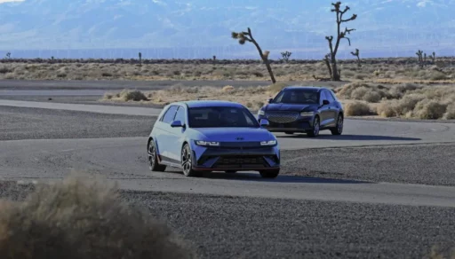 Dos coches modernos en una carretera desértica.