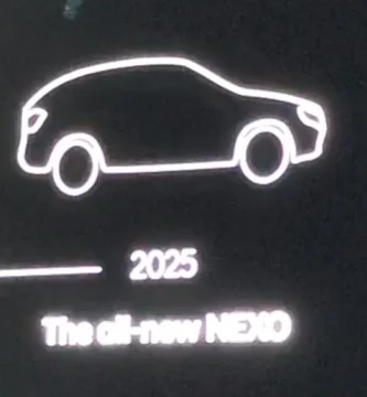 Símbolo luminoso de un coche con texto "2025 The all-new NEXO".