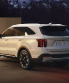 SUV blanco Kia aparcado en ambiente exterior nocturno.