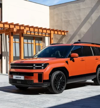 Camioneta SUV naranja estacionada en patio moderno.