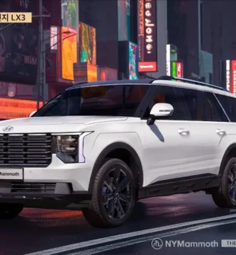 Un SUV blanco Hyundai Palisade en una calle urbana iluminada.