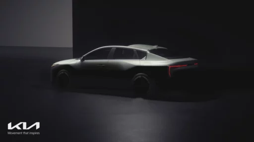 Un automóvil moderno iluminado sutilmente en una sala oscura.