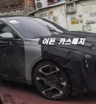 Auto camuflado con cubierta negra estacionado en la calle.