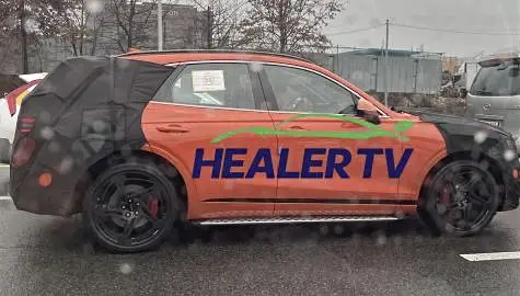 Un coche naranja con la inscripción "HEALER TV" en el costado.