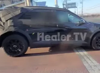 Vehículo camuflado con cobertura negra en prueba en carretera.