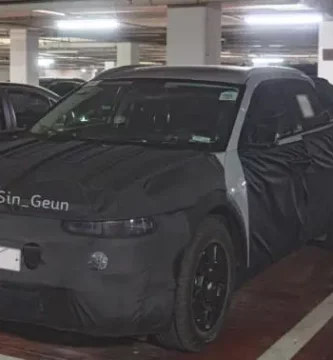 Coche con camuflaje de prueba estacionado en un garaje subterráneo.