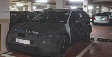 Coche con camuflaje de prueba estacionado en un garaje subterráneo.