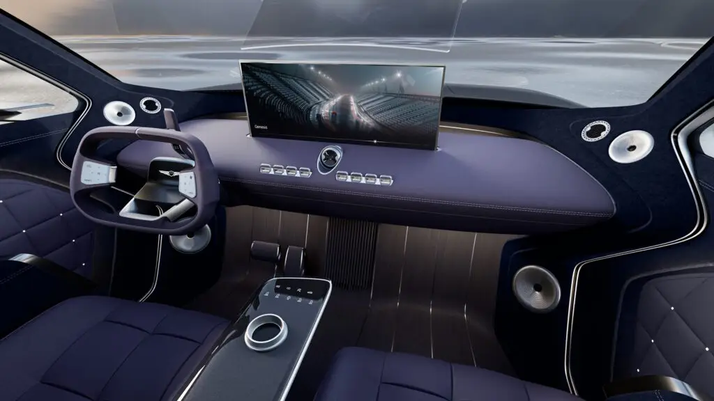 Interior moderno de un automóvil con pantalla grande y volante futurista.