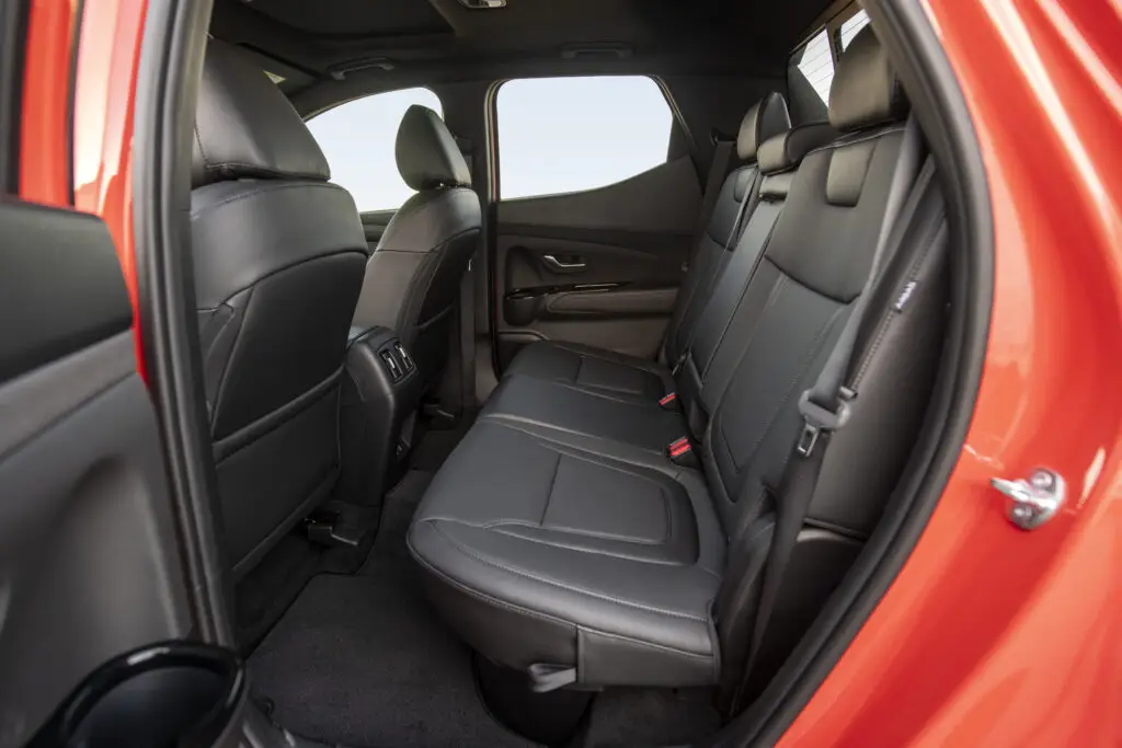 Interior del asiento trasero de un coche rojo.