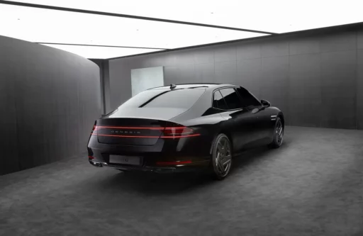Automóvil Genesis G90 negro en una sala moderna iluminada.