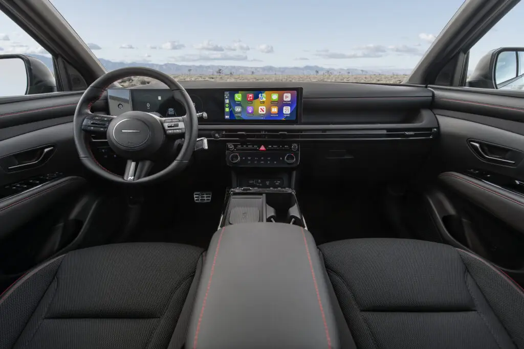 Interior moderno de automóvil con pantalla táctil y volante deportivo.
