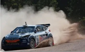 Auto de rally Hyundai derrapando en camino de tierra.