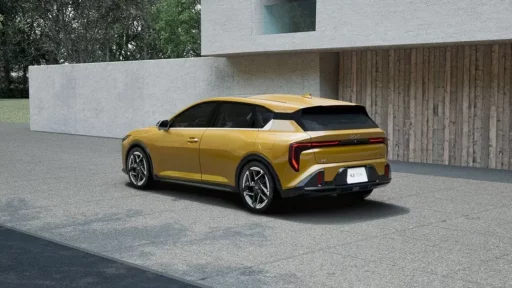 Auto deportivo amarillo estacionado frente a edificio moderno.