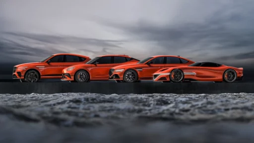 Cuatro vehículos naranjas deportivos sobre una plataforma, con cielo nublado.