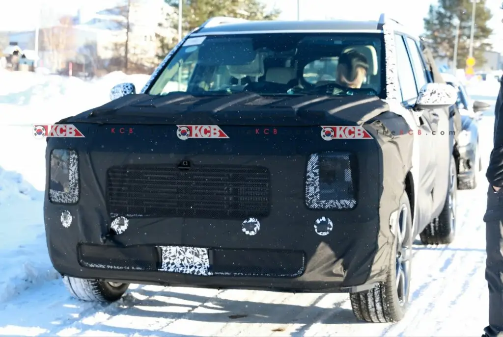 Vehículo camuflado en pruebas sobre una carretera nevada.