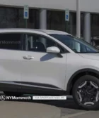 Vehículo SUV blanco Kia Sportage aparcado frente a un edificio.