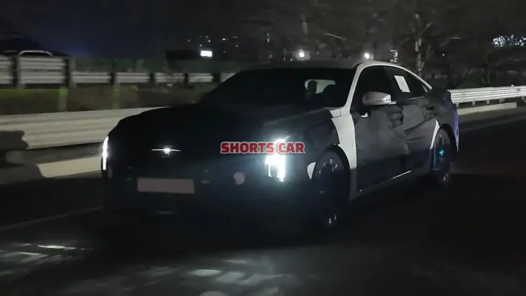 Un coche negro moviéndose de noche en la carretera.